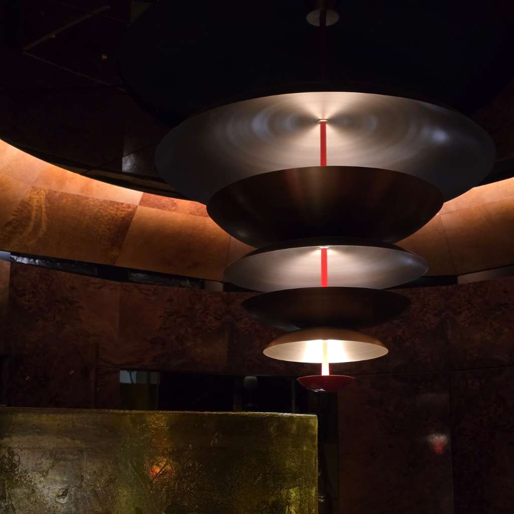 Sculptural pendant lighting in a dark luxury library interior