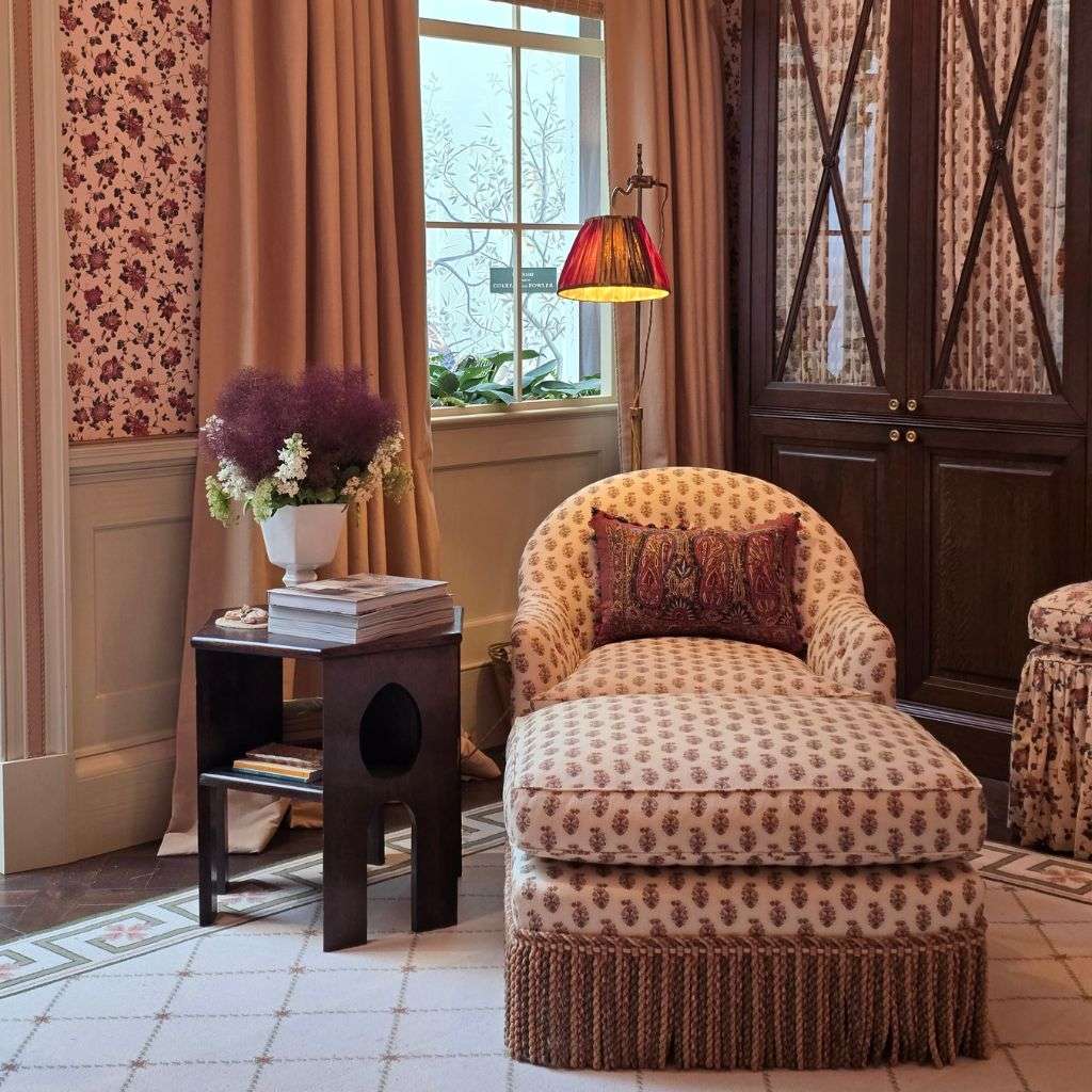 Printed upholstered chaise lounge with floral wallpaper in luxury bedroom