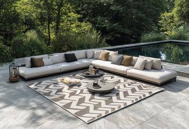 Chevron outdoor rug with beige modular sofa by poolside terrace.
