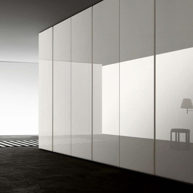 Luxury bedroom with fitted wardrobes installed over carpet showing seamless integration