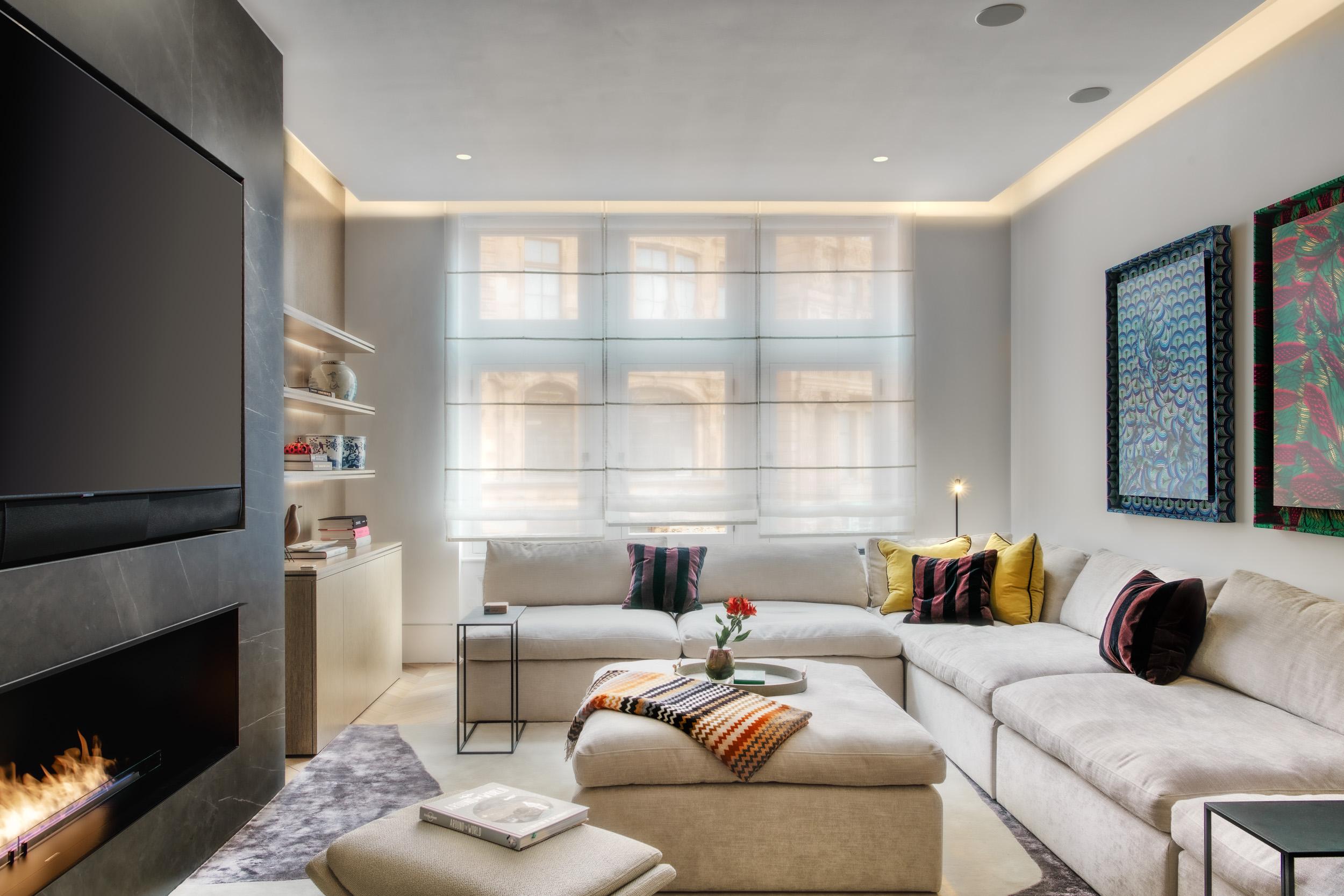 Neutral-toned living room with L-shaped sectional sofa in front of window