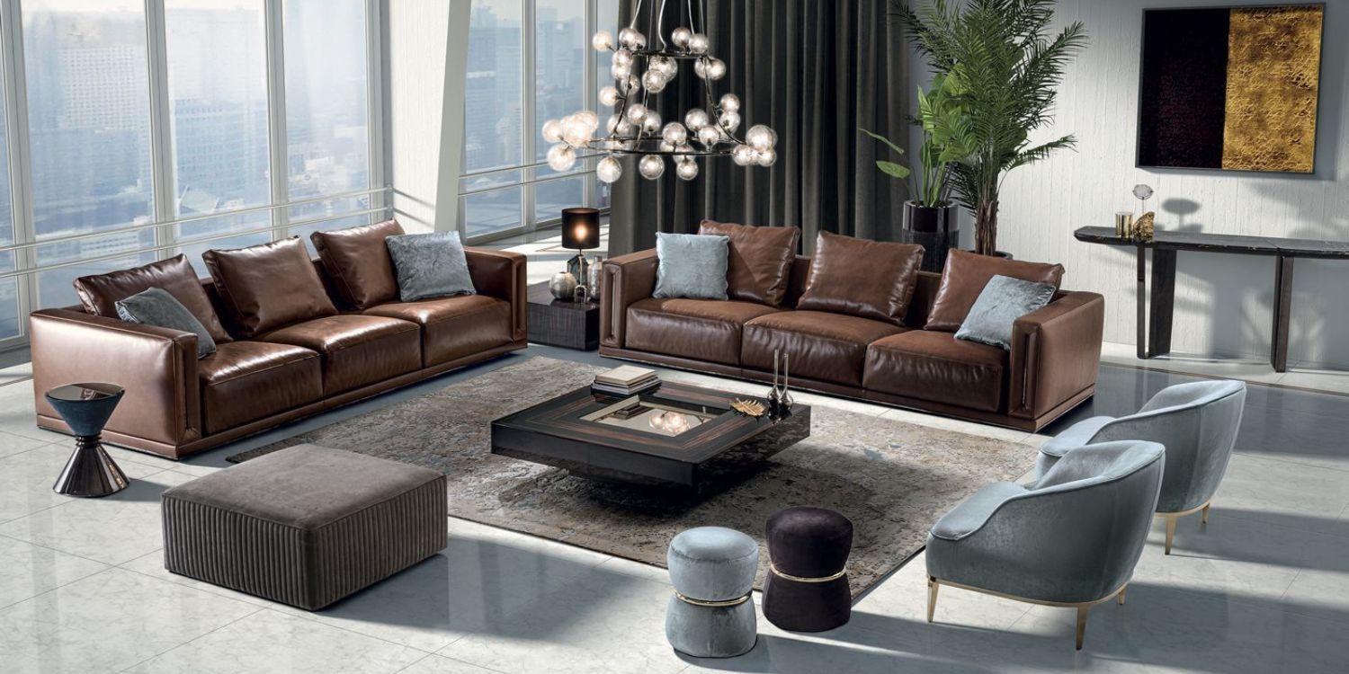 Glossy finish brown leather luxury upholstered L-shaped seater sofas in an elegant living room setting