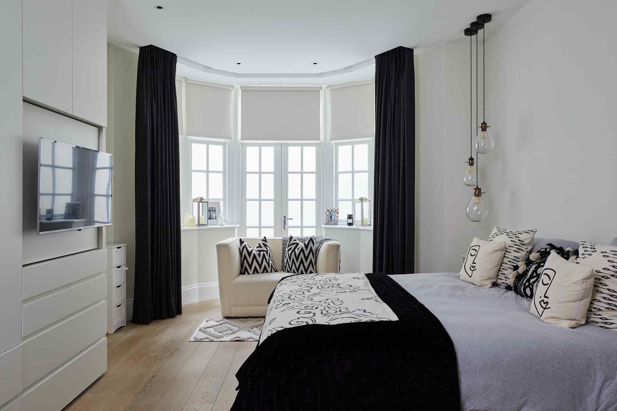 Bedroom with comfortable seating area featuring armchairs by window