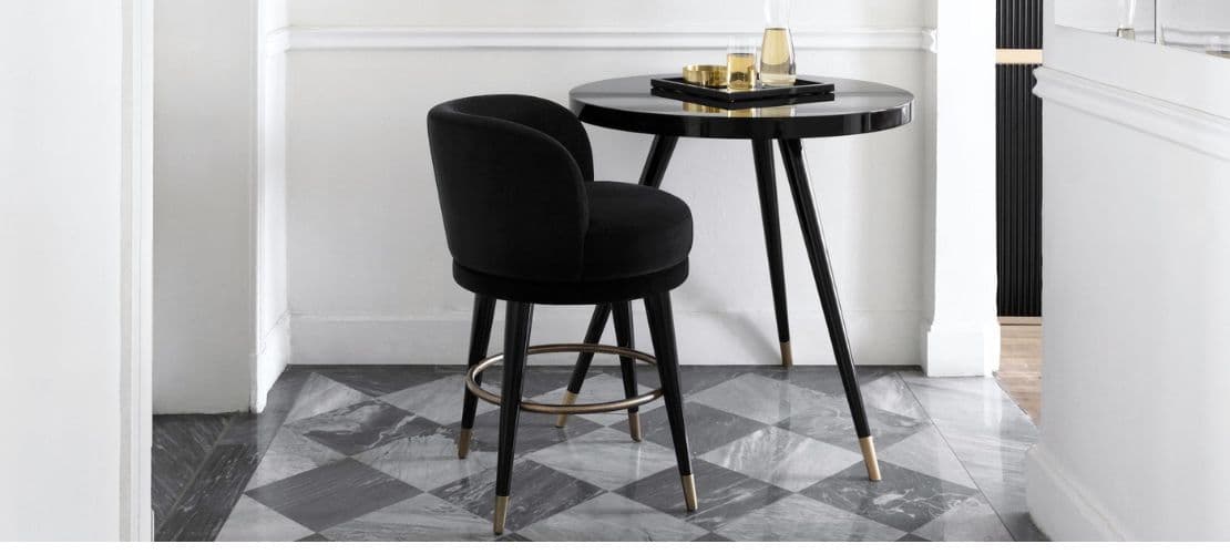 Sleek black round table with gold details, styled by Dom Edizioni.