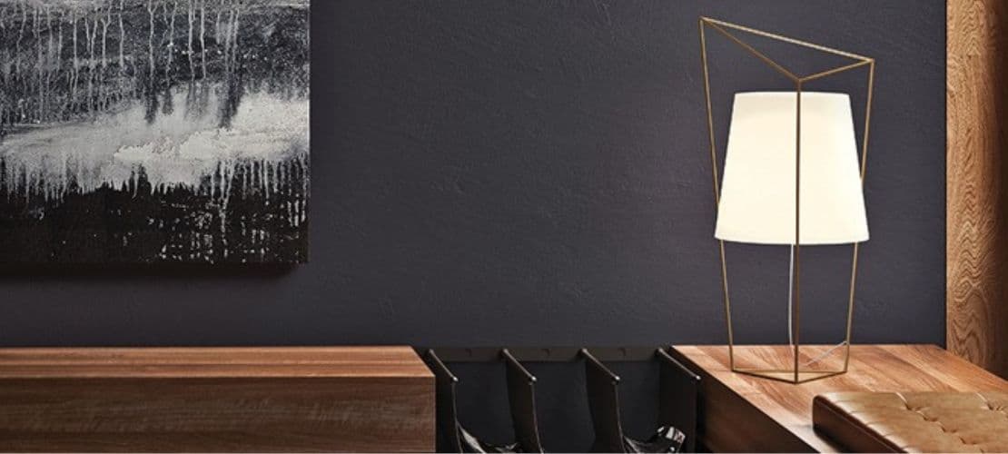 KDLN geometric brass table lamp with white shade on walnut desk.