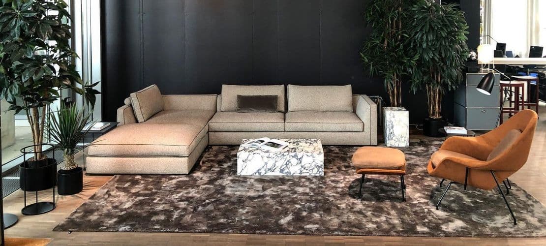 miinu textured rug grounding a modern lounge with beige modular sofa and marble tables.