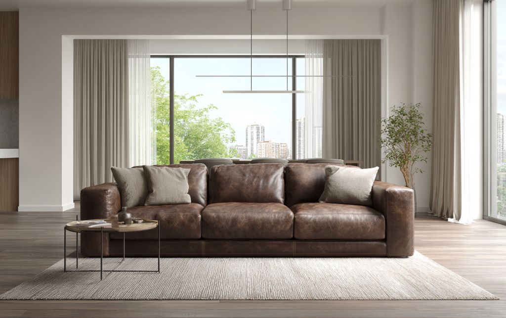 Professional leather care specialist treating luxury sofa with specialised cleaning and conditioning products