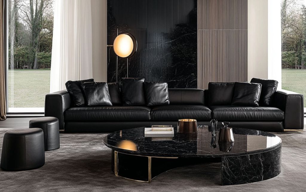 Black leather sofa with plush pillows and round black marble coffee table.