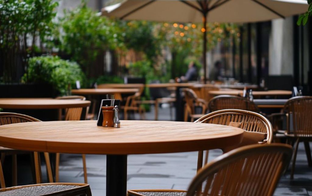 Extending outdoor dining table in an outdoor dining setup