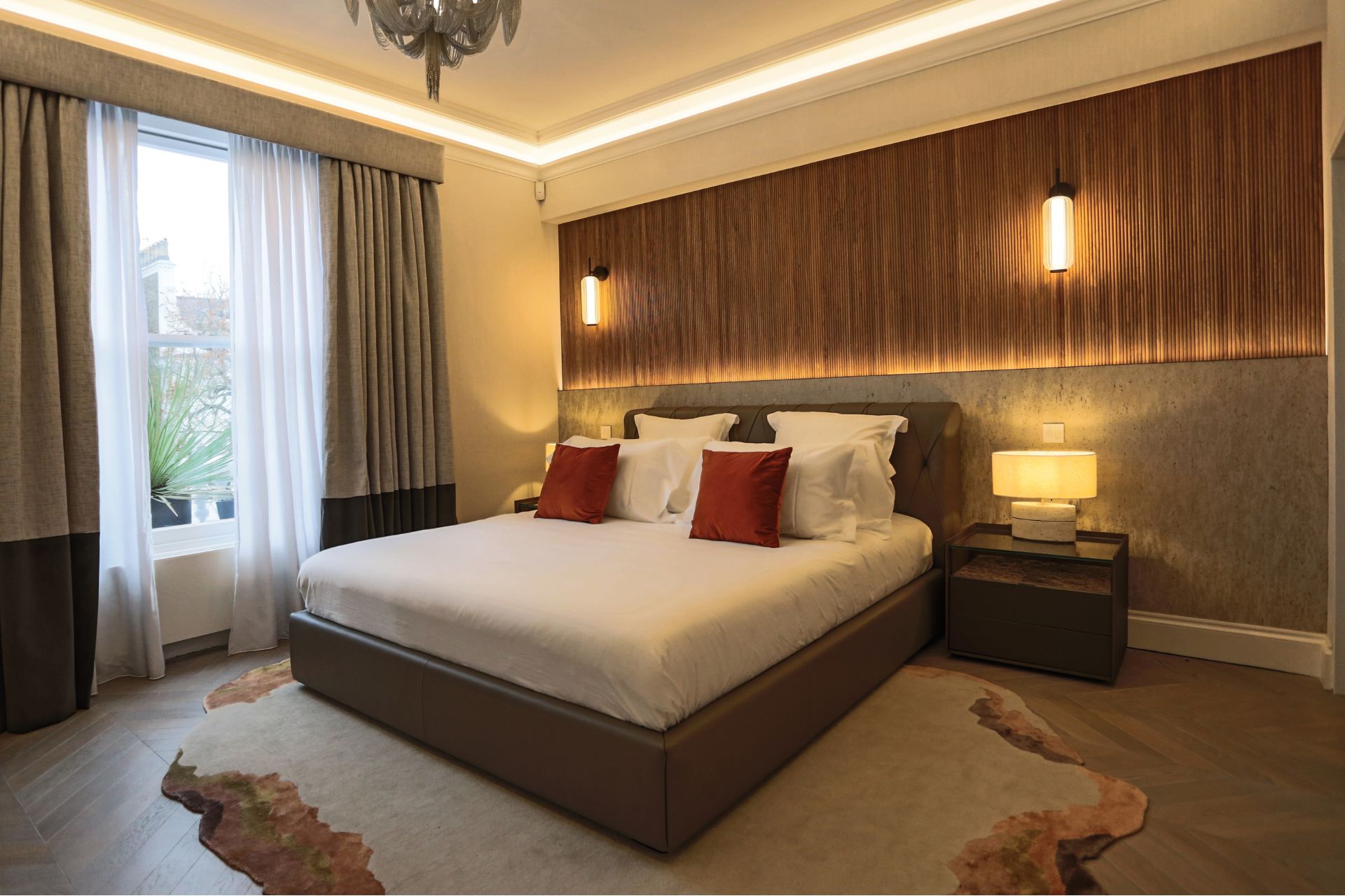 Cozy master bedroom with wood paneling and soft lighting.