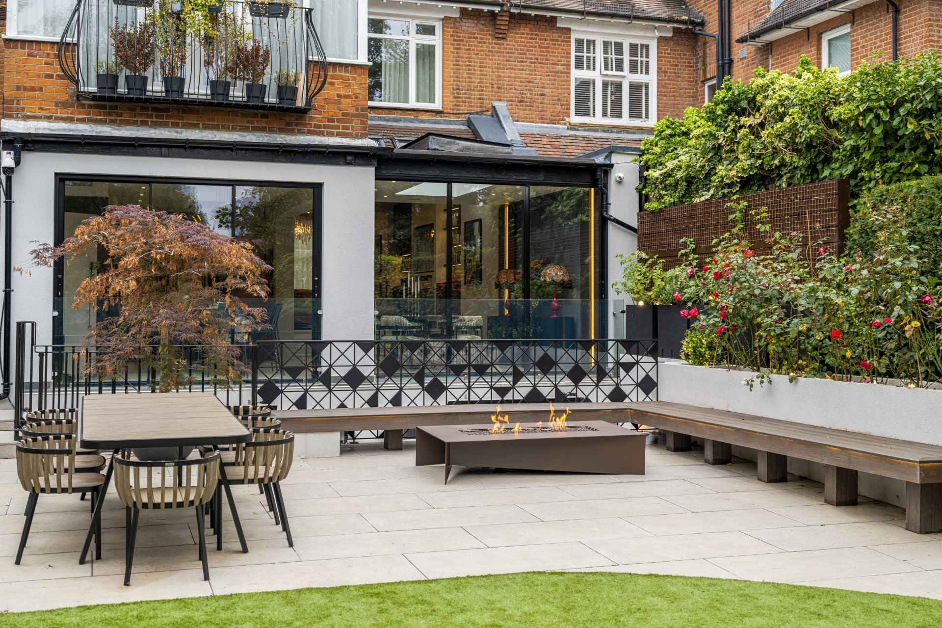 Outdoor patio with dining table, bench seating, and fire pit