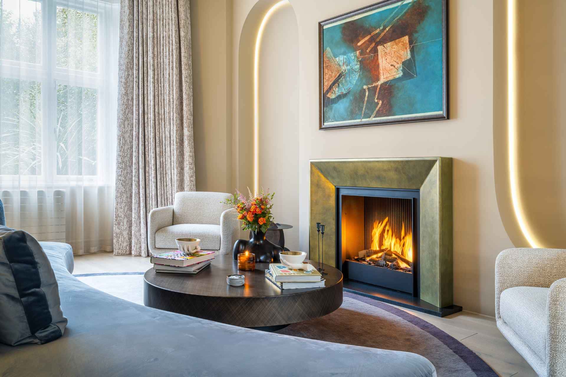 Living room featuring a modern fireplace, art piece, and armchairs.