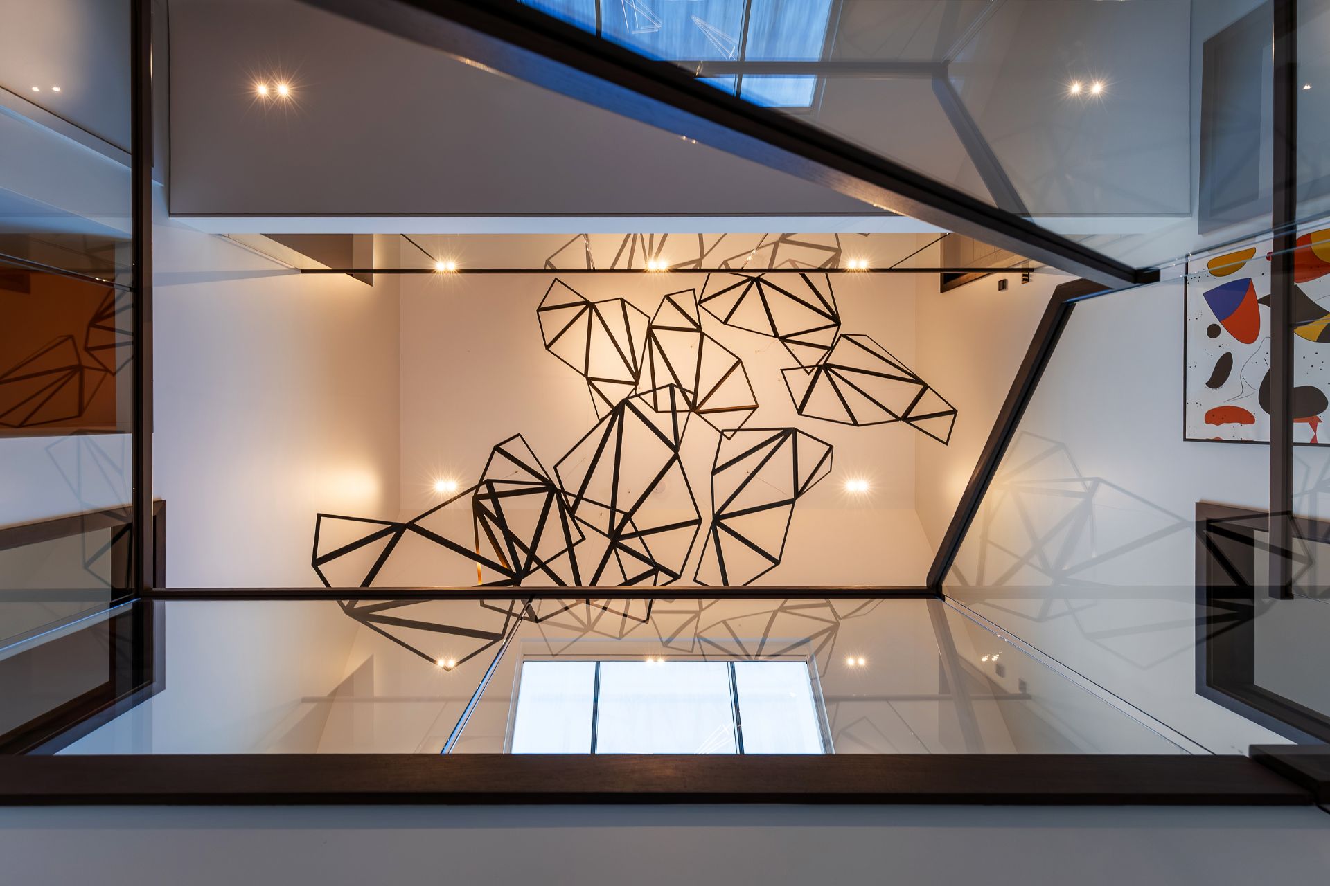 View of architectural ceiling art with geometric lines in a modern home.