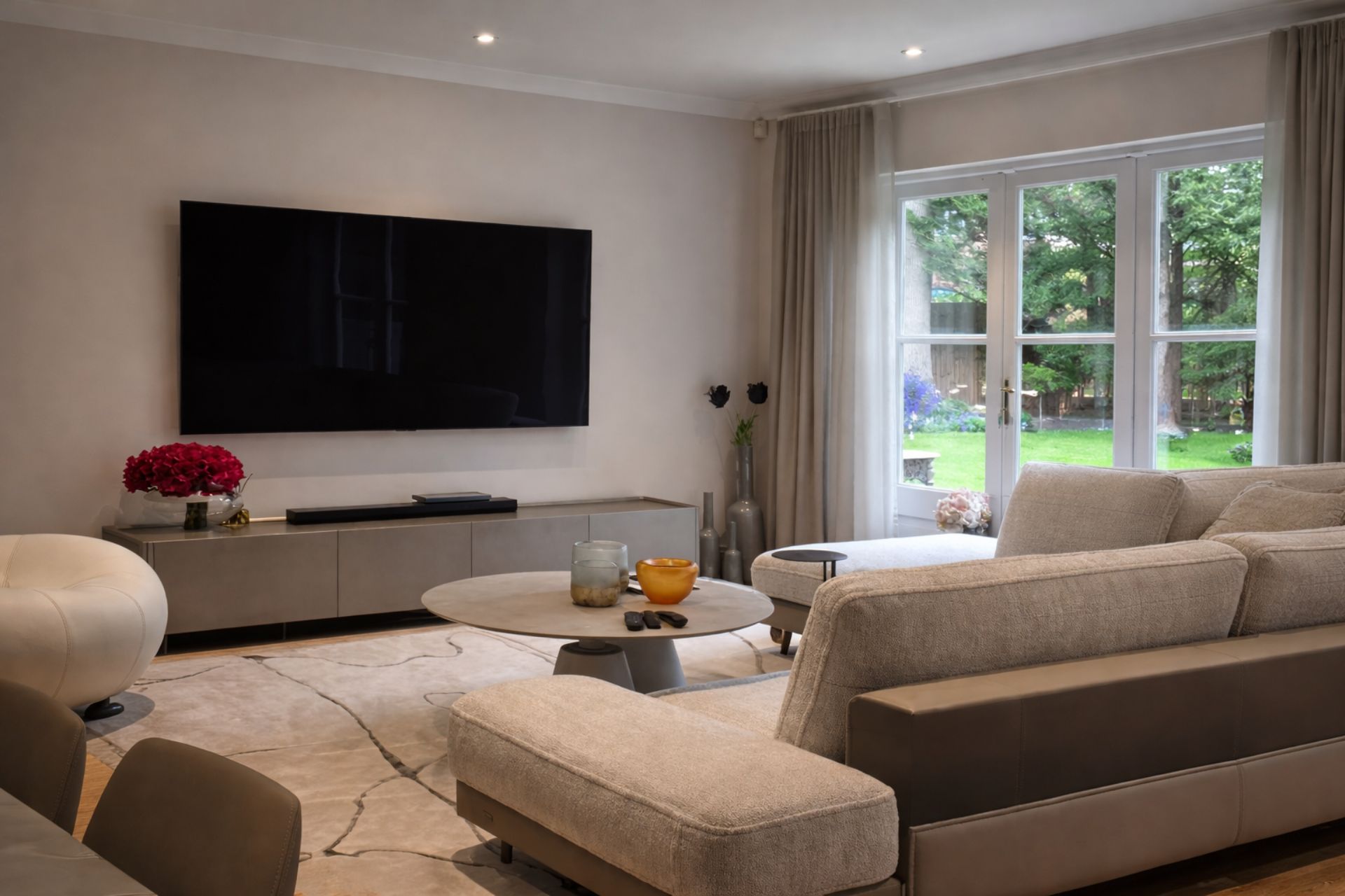 Modern living room with a teal sectional sofa, decorative cushions, and colorful artwork on the walls.